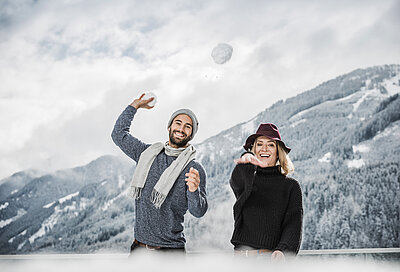 Paar schießt Schneebälle im 5 Sterne Hotel STOCK resort