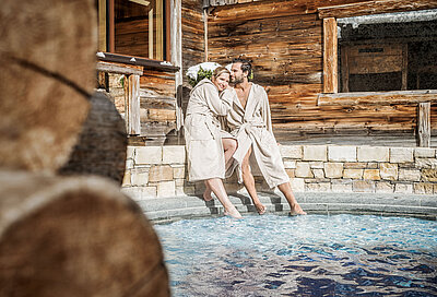 Paar am Outdoor Whirlpool im 5 Sterne Wellnesshotel STOCK resort
