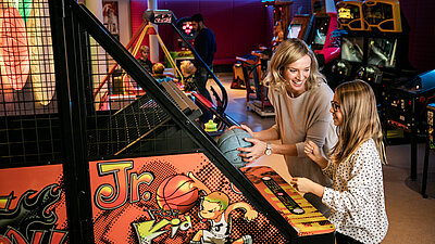Frau und Kind im Gamecenter im Familienhotel STOCK resort Österreich