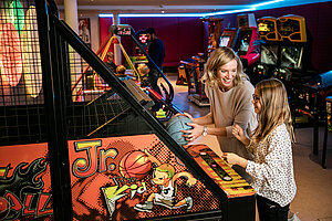 Frau und Kind im Gamecenter im Familienhotel STOCK resort Österreich