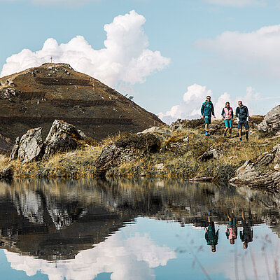 BikeHike_Wimbachkopf_171©zillertaltourismus_monepic Wanderer am Bergsee auf dem Wimbachkopf im Wanderurlaub Zillertal