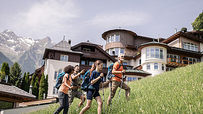 Wanderer neben dem Sporthotel STOCK resort Österreich