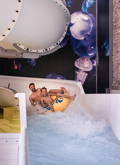 Vater und Sohn beim Rutschen im Familienhotel STOCK resort Österreich