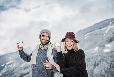 Paar beim Schneeball werfen im Luxushotel Zillertal STOCK resort